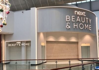 Next beauty and home shop front with illuminated signs