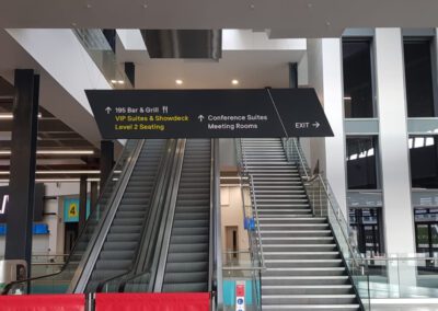 Teca Even Complex Aberdeen hanging wayfinding sign above escalator