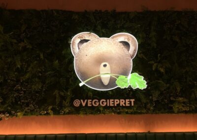 Illuminated light box sign on living wall inside Pret A Manger Veggie Pret