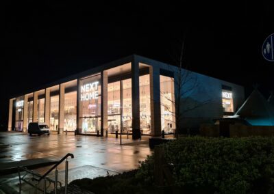 Outside Next Store with face illuminated letters