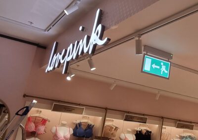 Illuminated block acrylic Love Pink letters hanging from bulkhead in Victorias Secret store