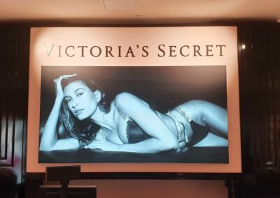 Illuminated fabric lightbox behind cash desk at Victoria's Secret